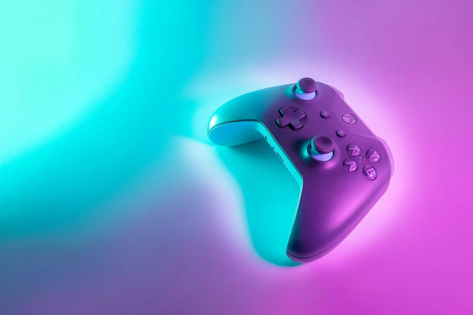 Turkuaz ve pembe neon ışıkla aydınlatılmış oyun kumandası